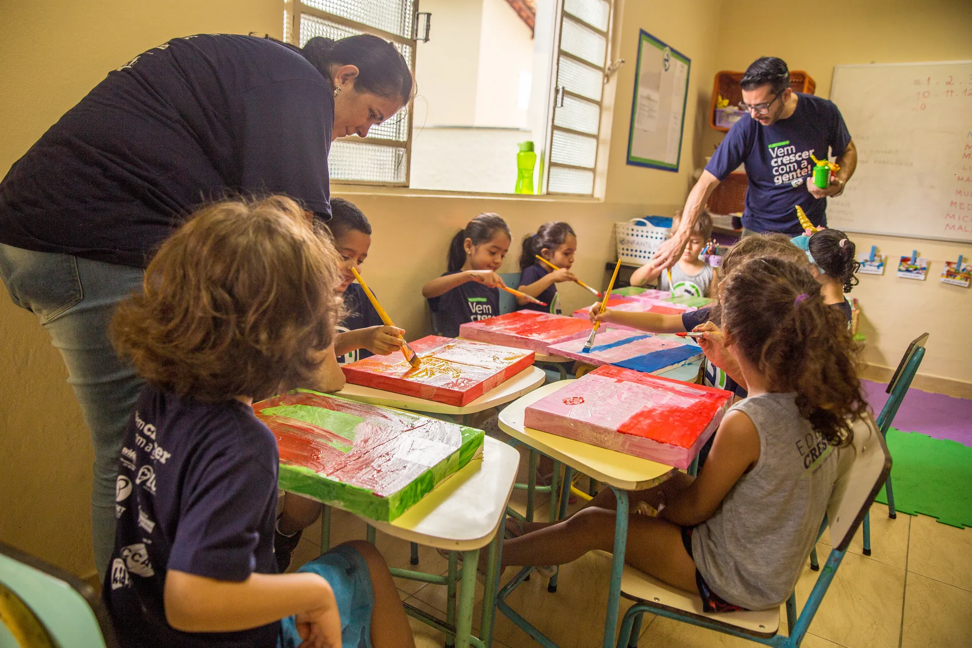 Educadoras acompanhando as crianças em atividade na sala