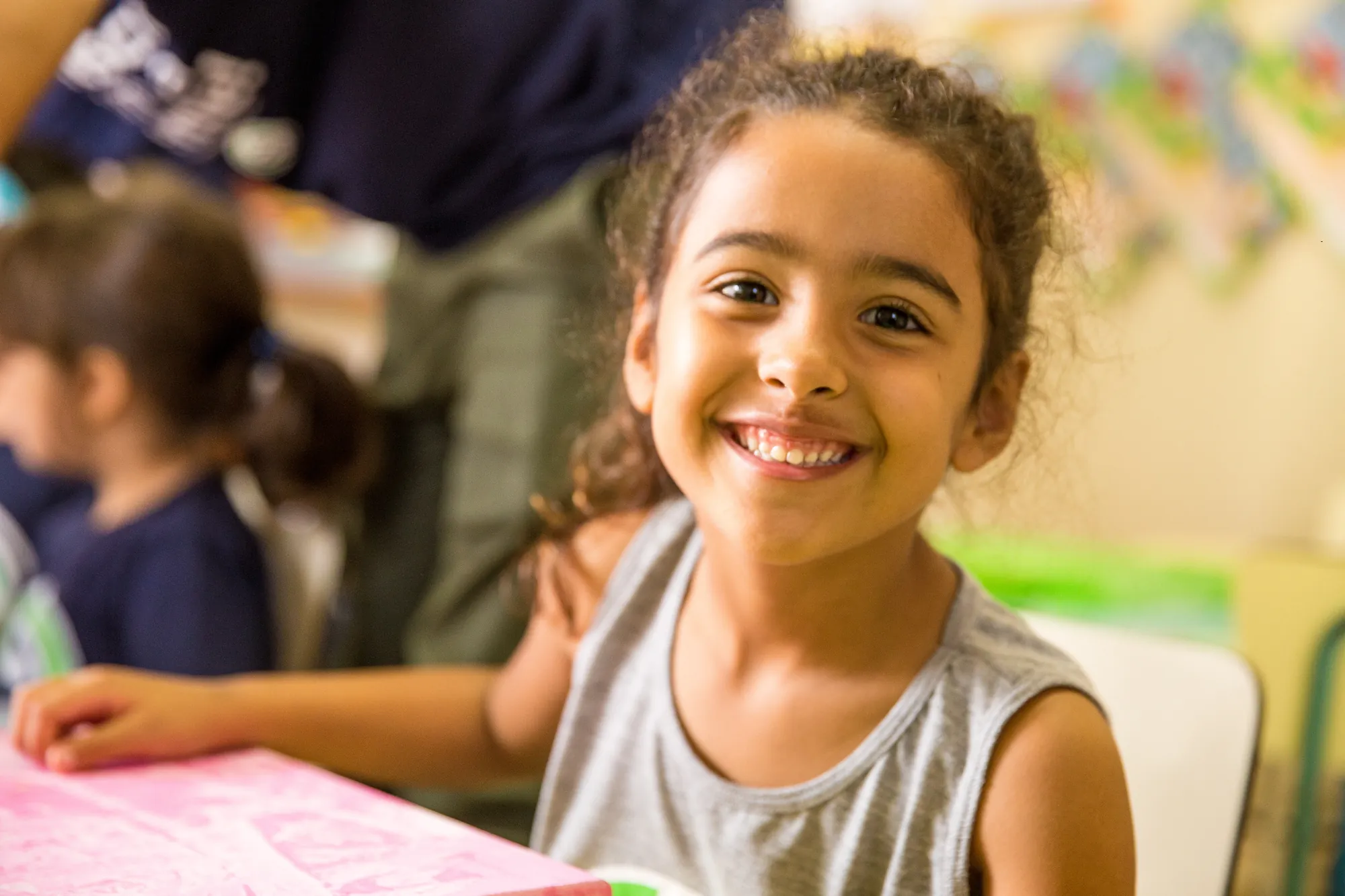 Menina sorrindo durante atividade em sala